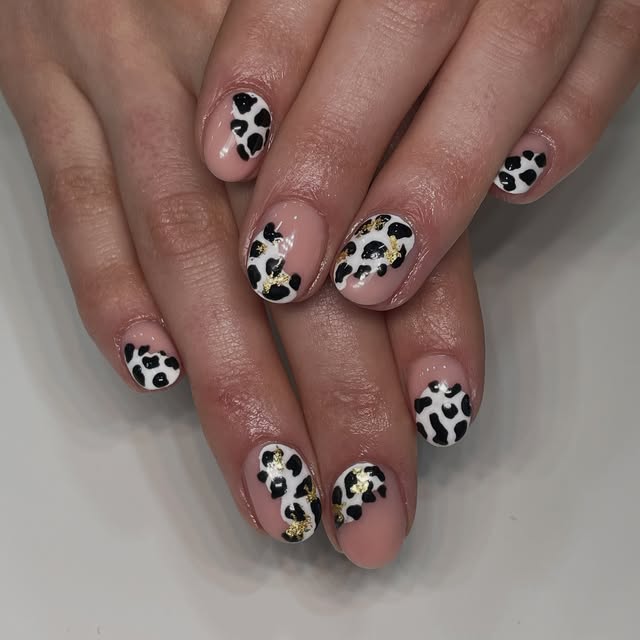 Black and white cow-print nail art created by BLOSSOM LONDON